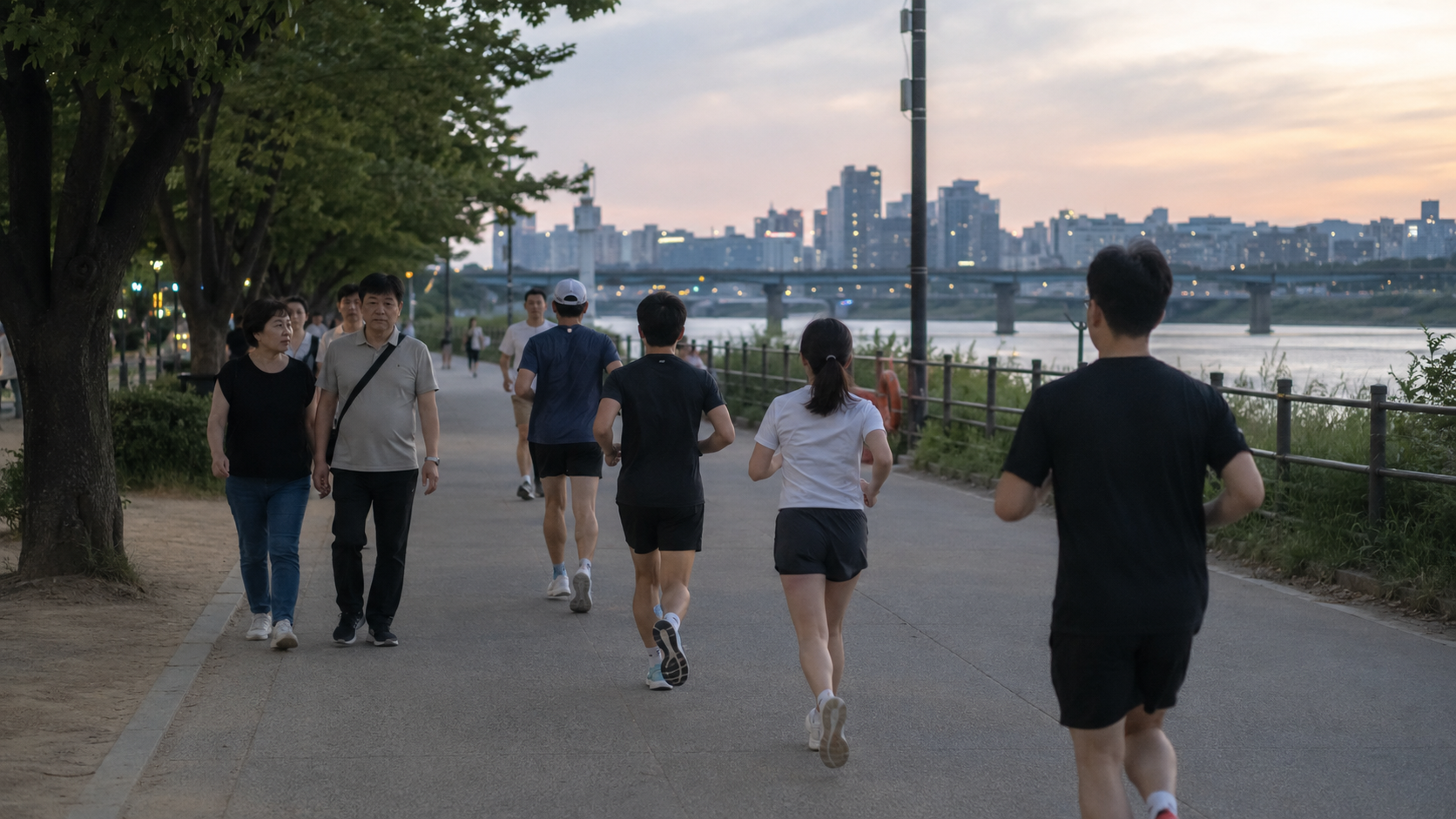산책객과 러너가 한 길을 공유하는 저녁 한강공원 산책로